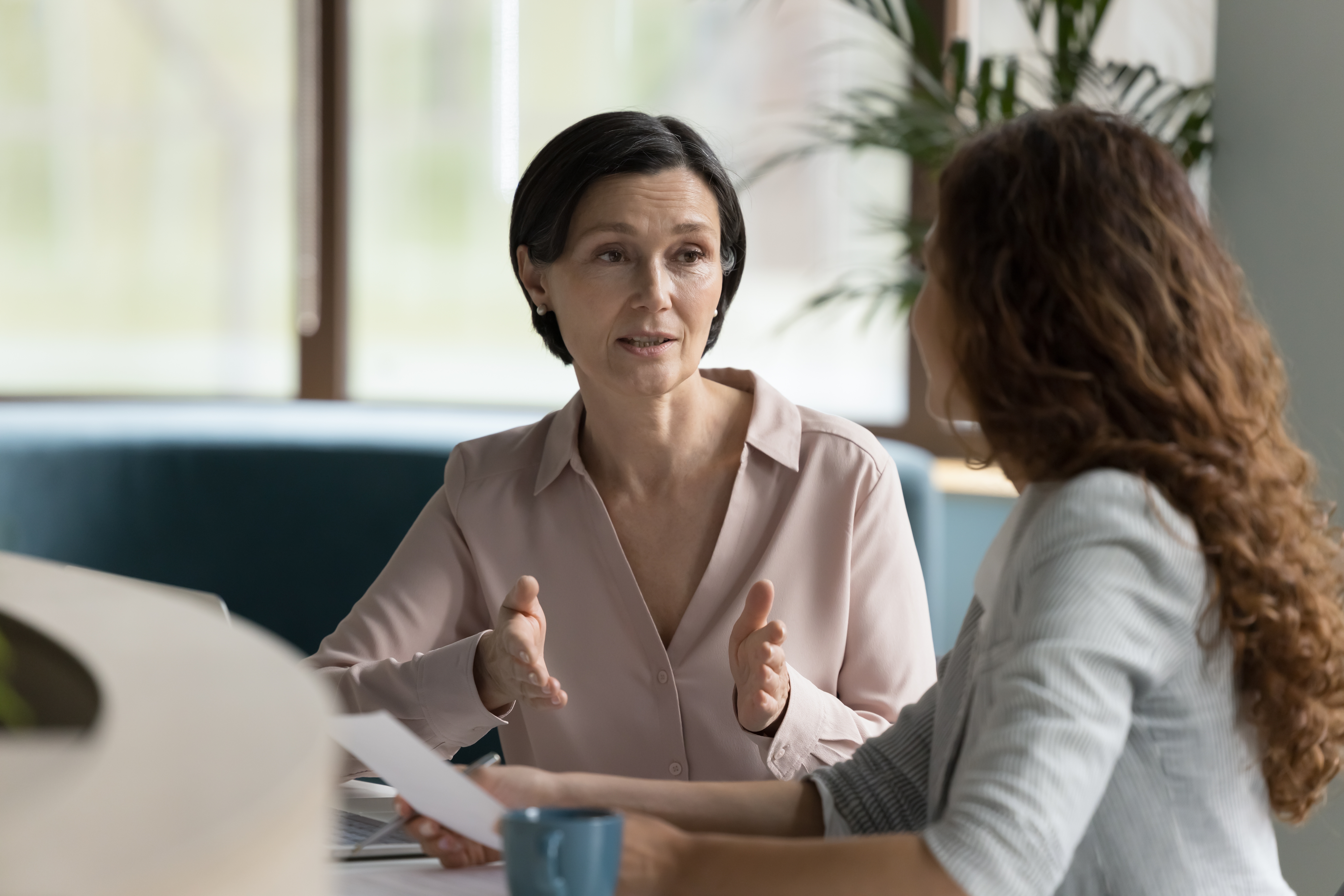 A person explaining something to another person in an office.