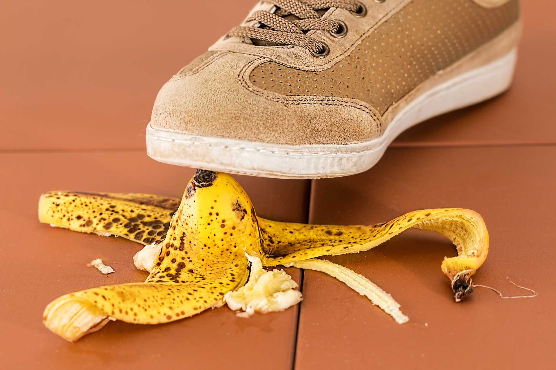 Close-up of person stepping on a banana skin