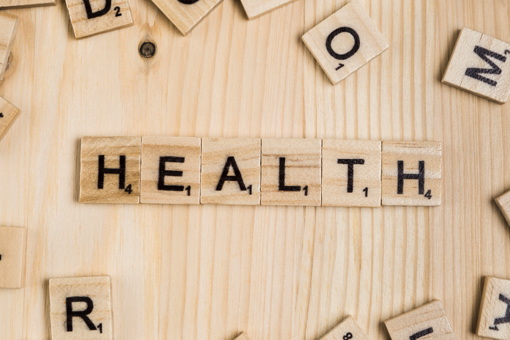 Scrabbles layed on a table with one set with the letters "HEALTH"