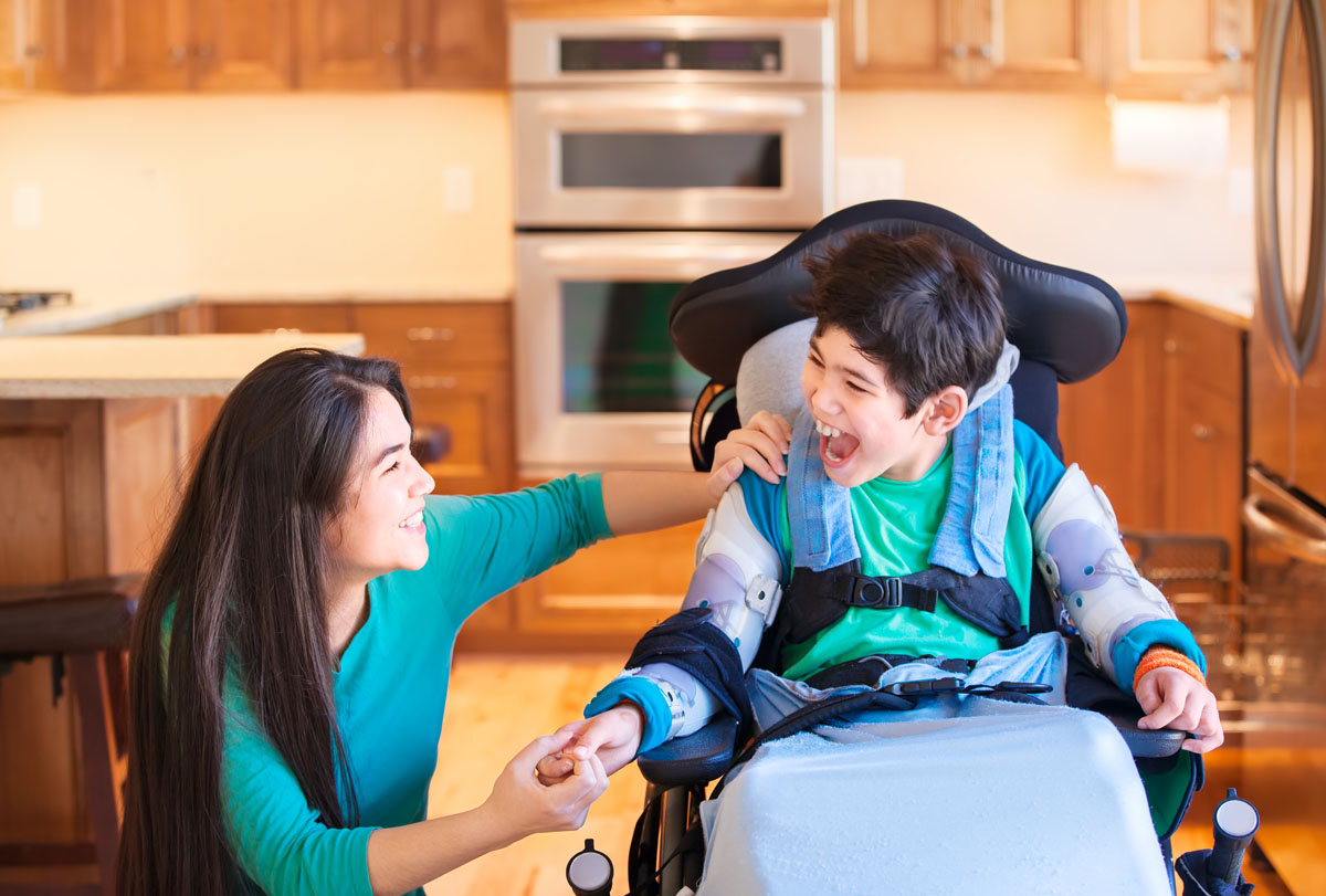 A smiling boy is sitting in a wheelchair