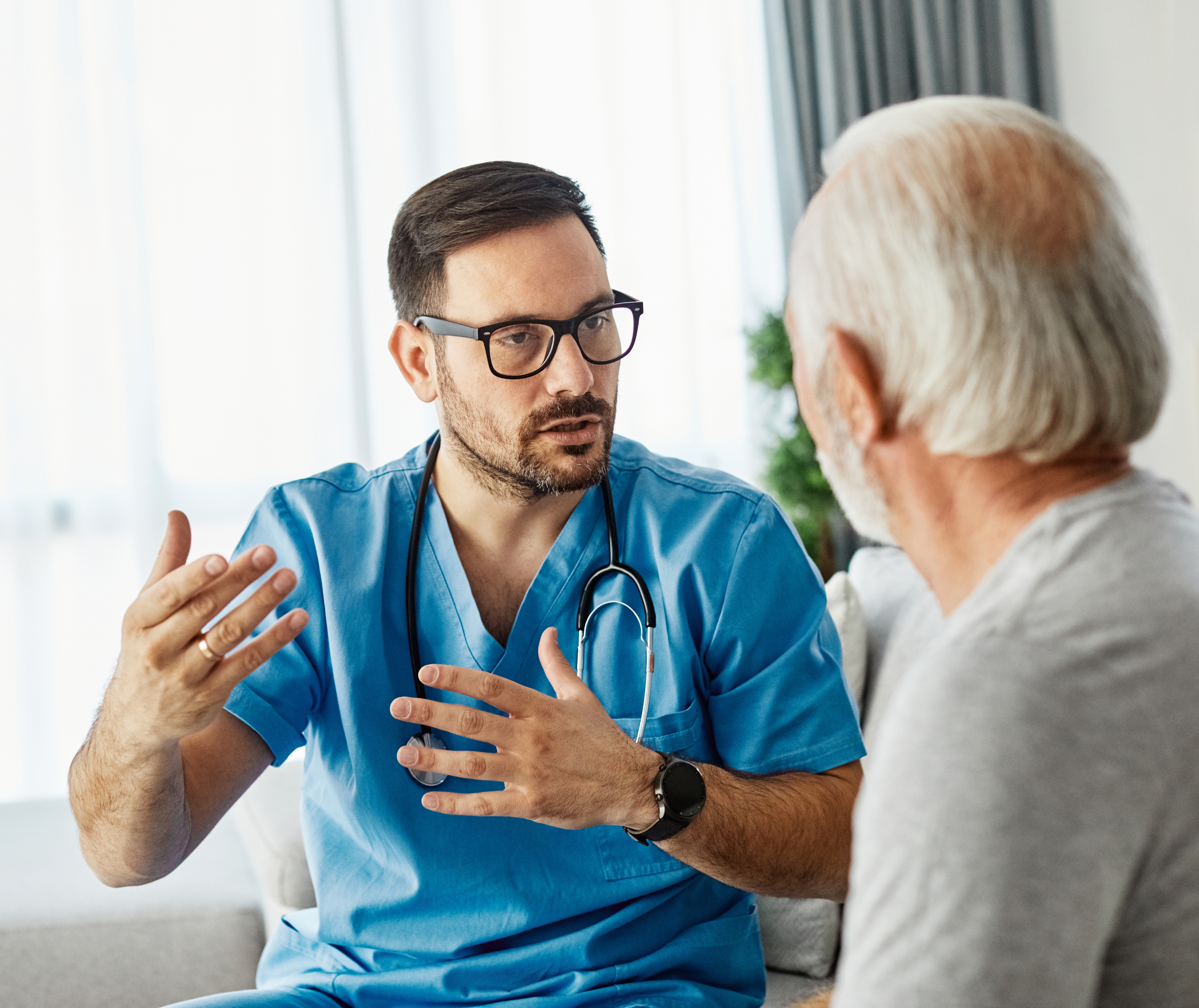 A healthcare worker is explaining something to an older patient.