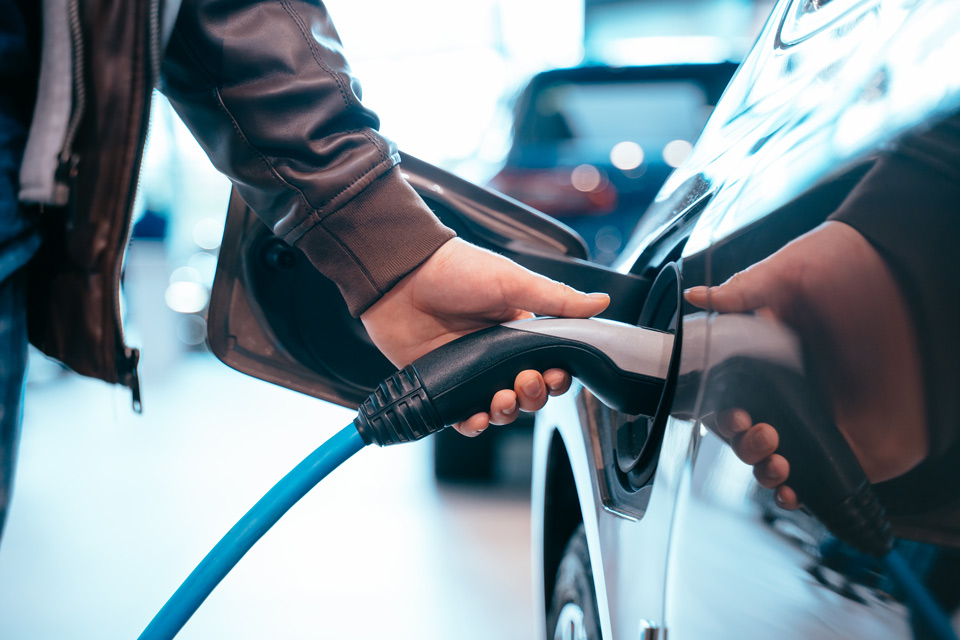 Person holder a car charger plug into the vehicle