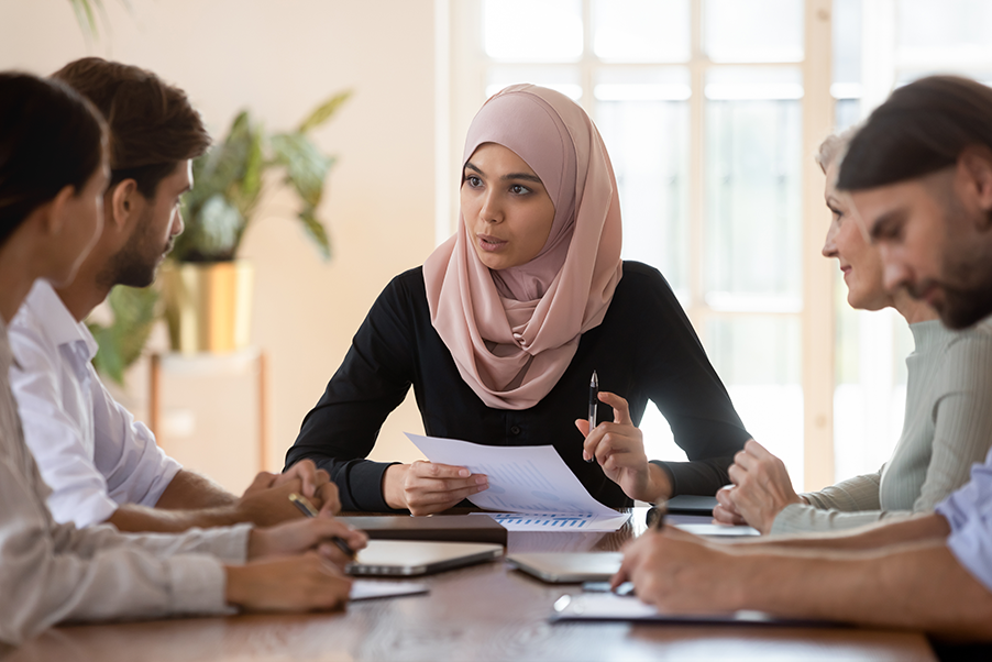 Group of culturally diverse individuals in conversation at a table